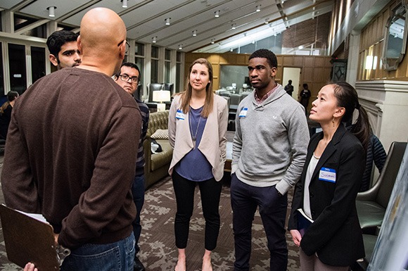 Grad students standing in a group speaking with each other